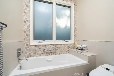 a bedroom with furniture and a large window