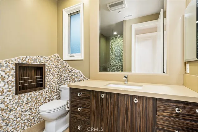 a front view of a house with plants and trees