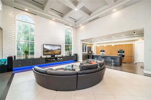 a living room with furniture a large window with kitchen view