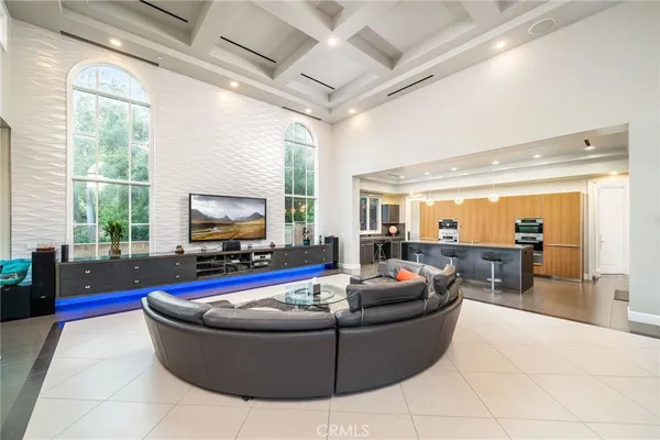 a living room with furniture a large window with kitchen view