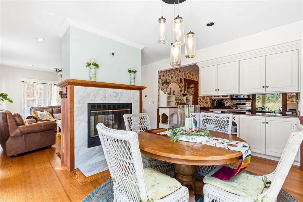 840 Fisher Road Fitchburg, MA 01420 - Photo 12 of 42 a dining table with a fireplace and kitchen view