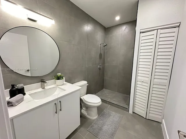 a bathroom with a toilet a sink and a mirror