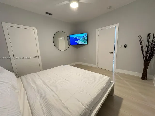 a bedroom with a bed and a flat screen tv
