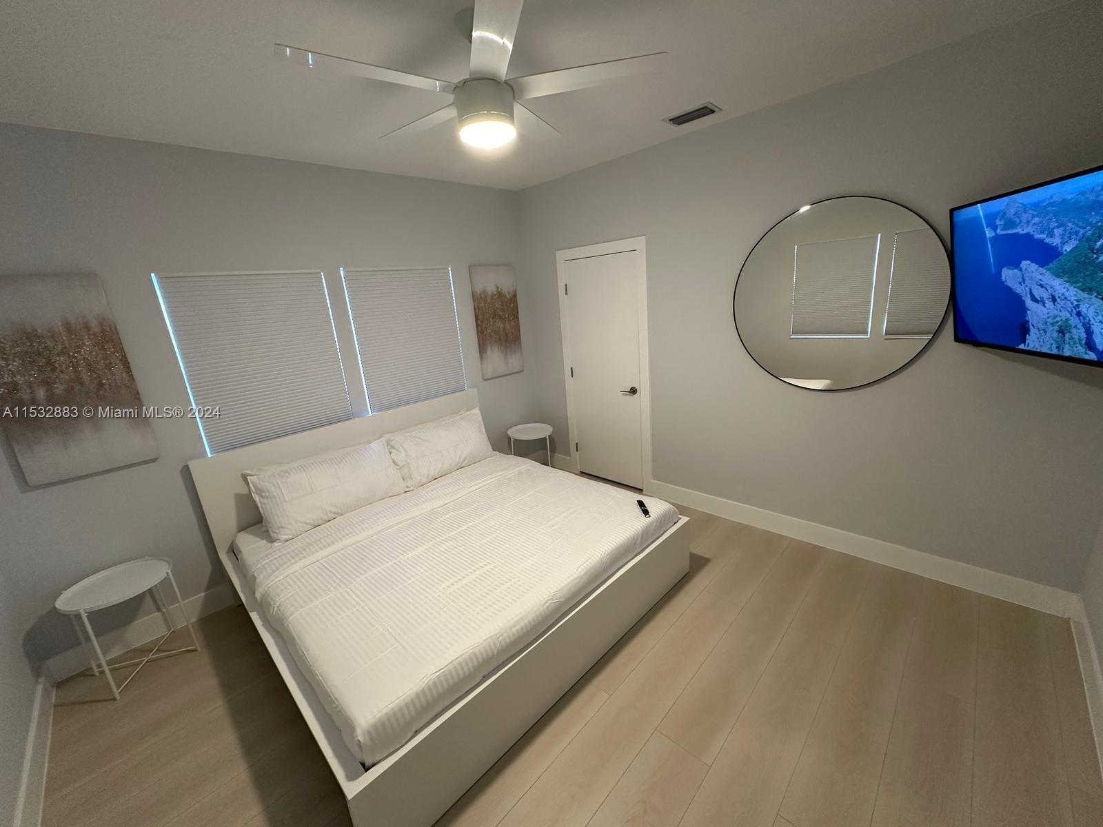 994 Northwest 2nd Street Miami, FL 33128 - Photo 14 of 30 a bedroom with a bed and a chandelier