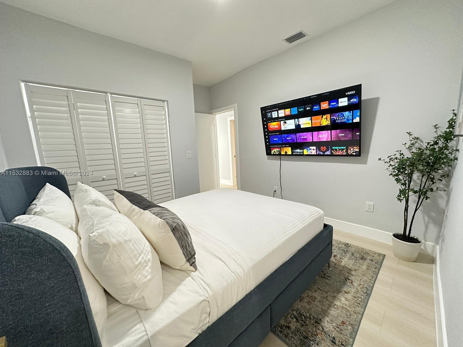 994 Northwest 2nd Street Miami, FL 33128 - Photo 15 of 30 a bedroom with bed and a flat screen tv