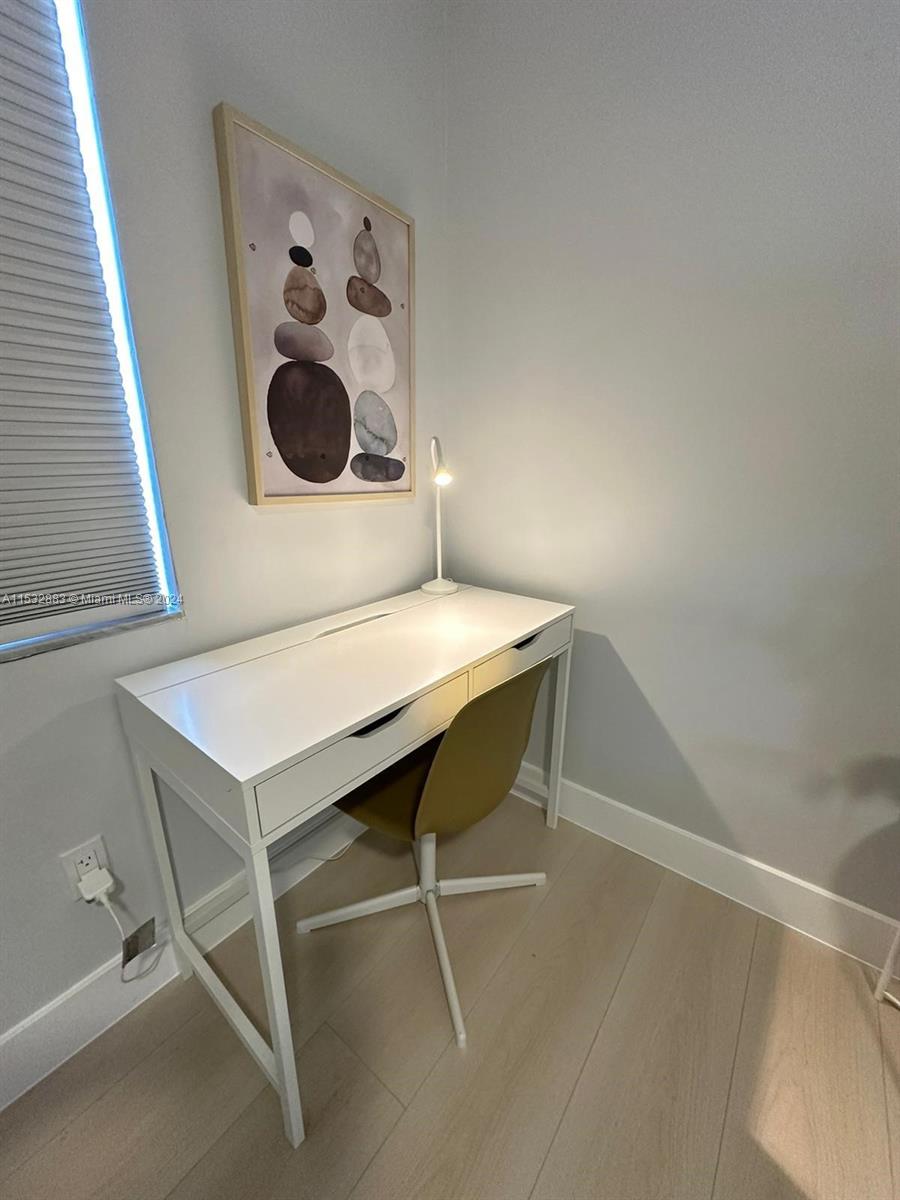 994 Northwest 2nd Street Miami, FL 33128 - Photo 16 of 30 a workspace with a table and white cabinetry