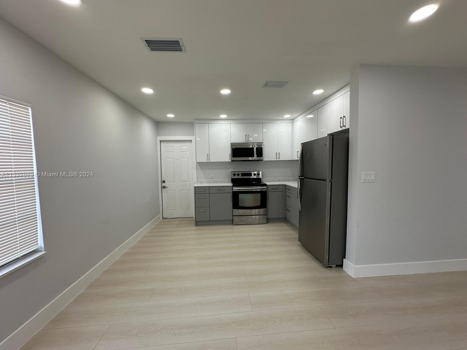 994 Northwest 2nd Street Miami, FL 33128 - Photo 24 of 30 a view of kitchen with refrigerator and microwave