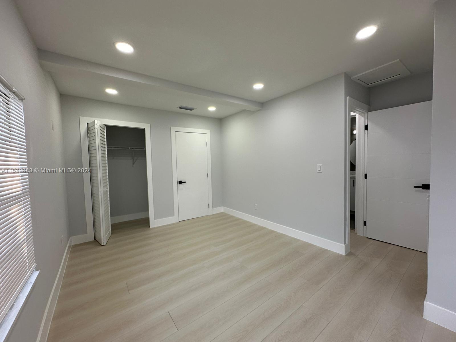 994 Northwest 2nd Street Miami, FL 33128 - Photo 28 of 30 an empty room with wooden floor and closet area