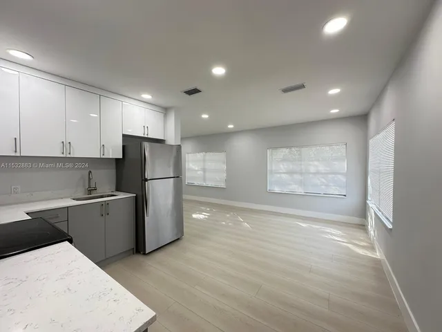 a kitchen with a refrigerator and a sink