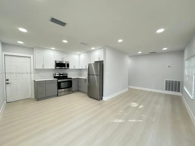 a view of kitchen with refrigerator and microwave
