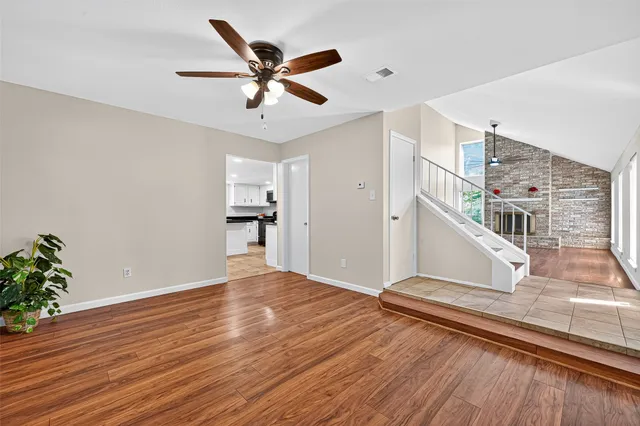 a view of a livingroom with wooden floor and a ceiling fan
