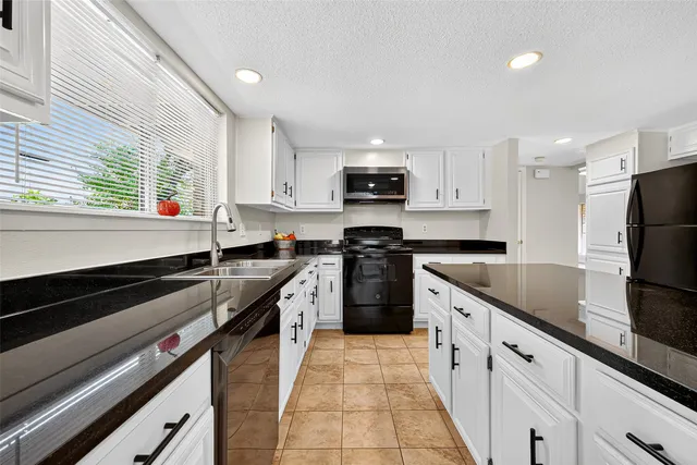 a kitchen with stainless steel appliances granite countertop a sink a stove and a refrigerator