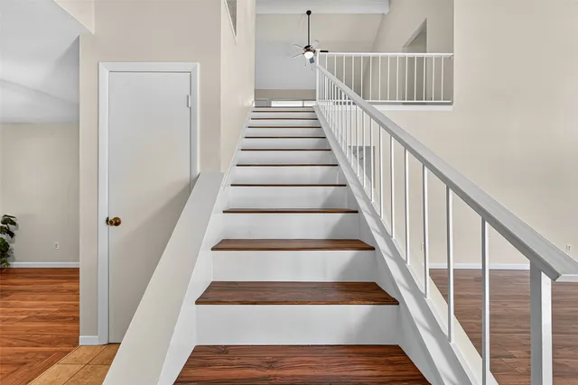 a view of staircase with wooden floor and white walls
