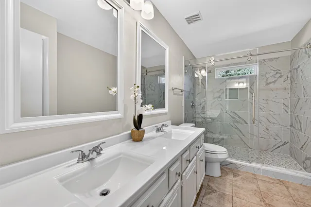 a bathroom with a sink a toilet and shower