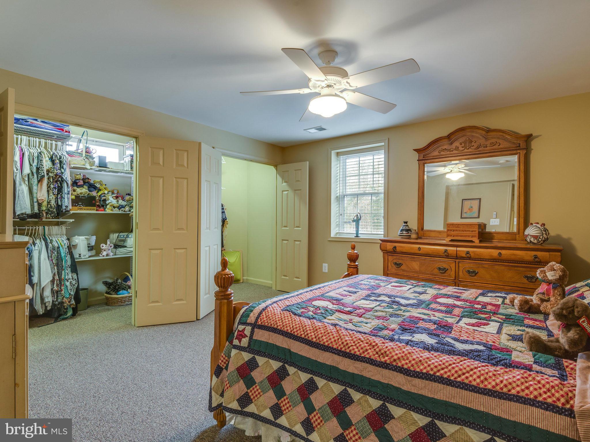 22570 Forest Manor Drive Ashburn, VA 20148 - Photo 15 of 30 a bedroom with a large bed and a chandelier