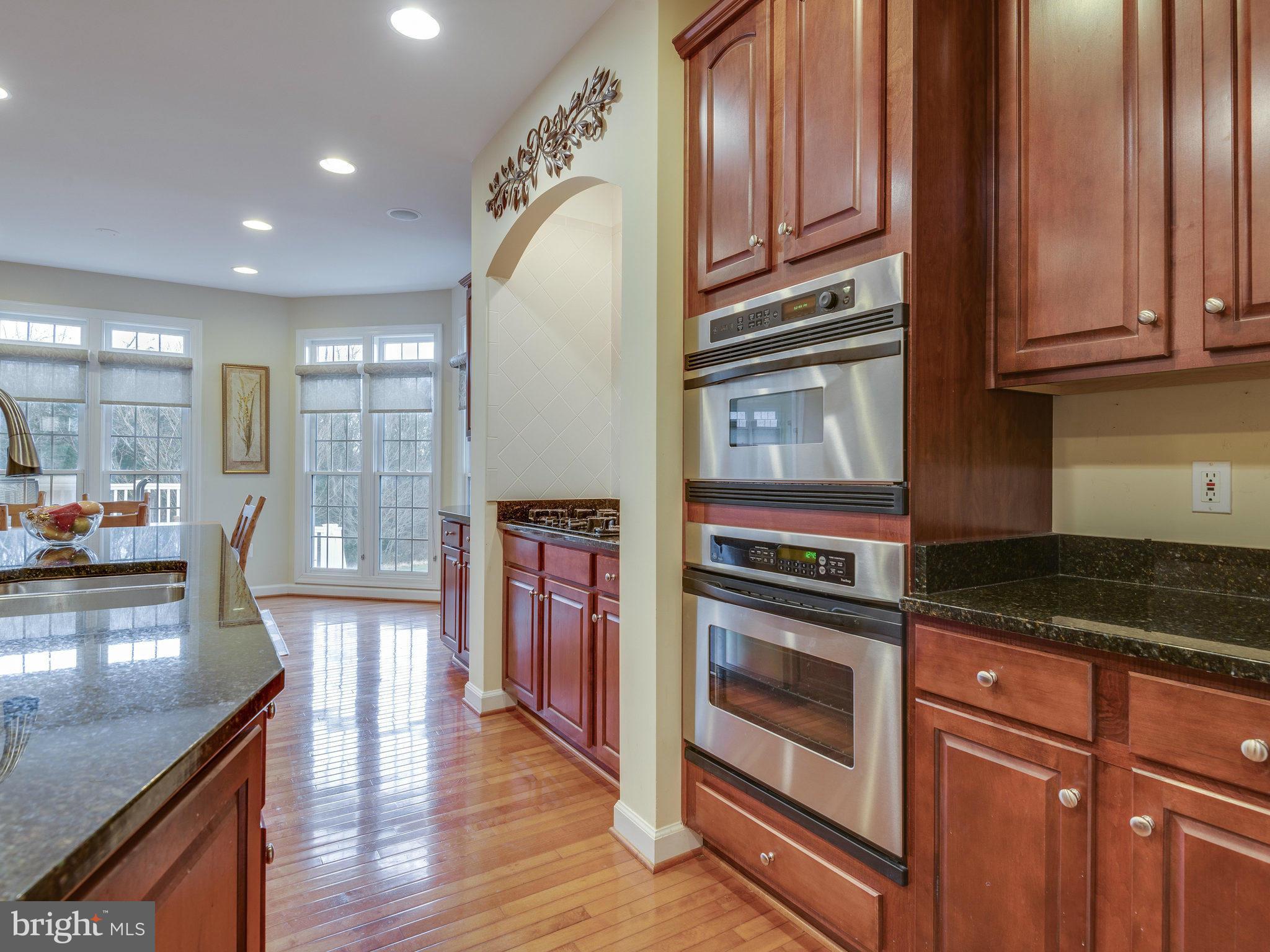 22570 Forest Manor Drive Ashburn, VA 20148 - Photo 4 of 30 a kitchen with stainless steel appliances granite countertop a stove and cabinets