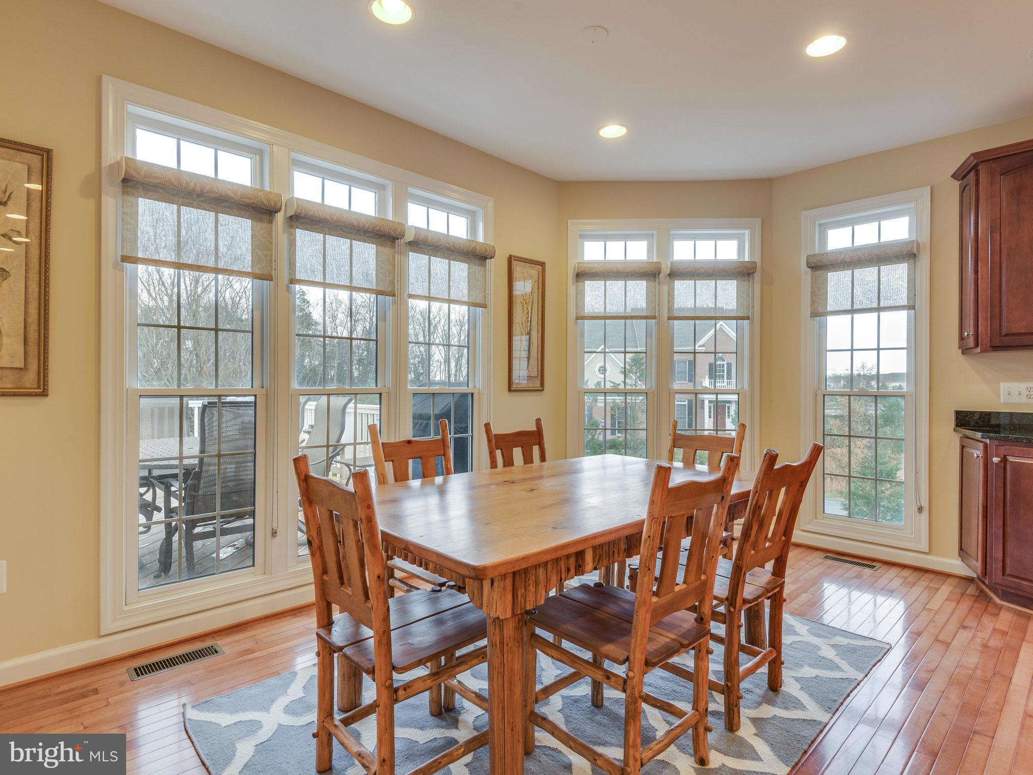 22570 Forest Manor Drive Ashburn, VA 20148 - Photo 6 of 30 a view of a dining room with furniture large windows and wooden floor