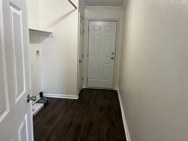 a view of an empty room with wooden floor and closet