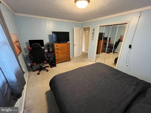 a bedroom with a bed and a flat tv screen