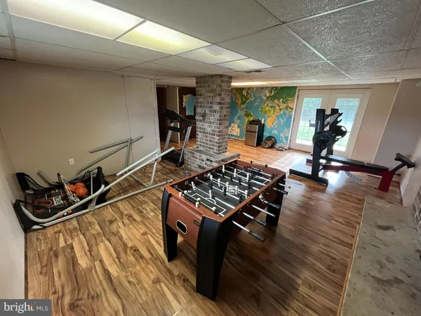 a living room with wooden floor and gym equipment