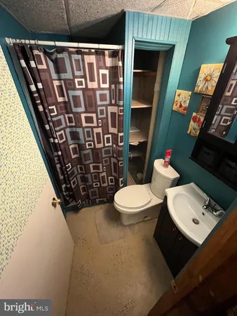 a bathroom with a toilet and a shower curtain