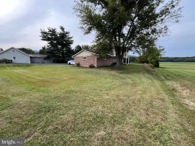 a front view of a house with a garden and trees