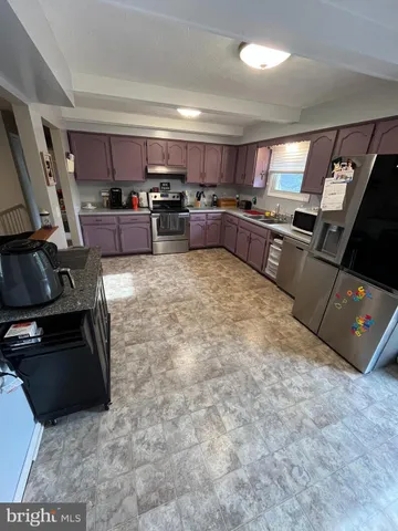 a large kitchen with cabinets and stainless steel appliances