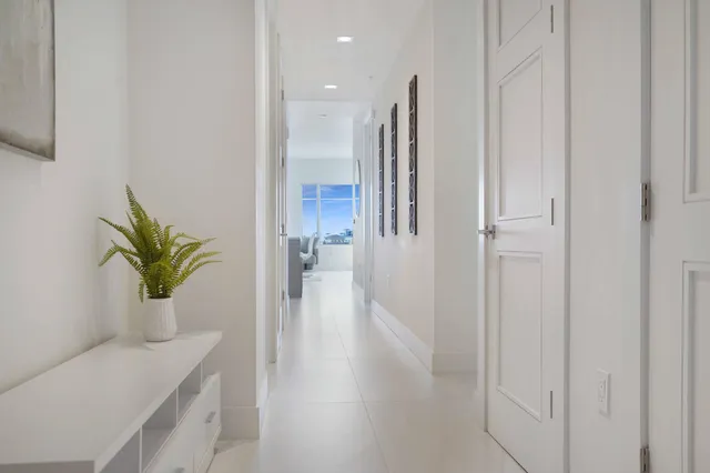 a view of a hallway with potted plants on wooden floor