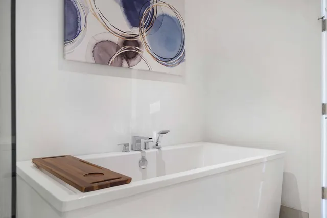 a bathroom with a sink a mirror and a potted plant