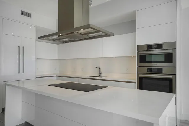 a kitchen with kitchen island a sink and stainless steel appliances