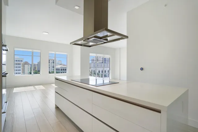 a kitchen with stainless steel appliances granite countertop a sink dishwasher a stove and white countertops with wooden floor