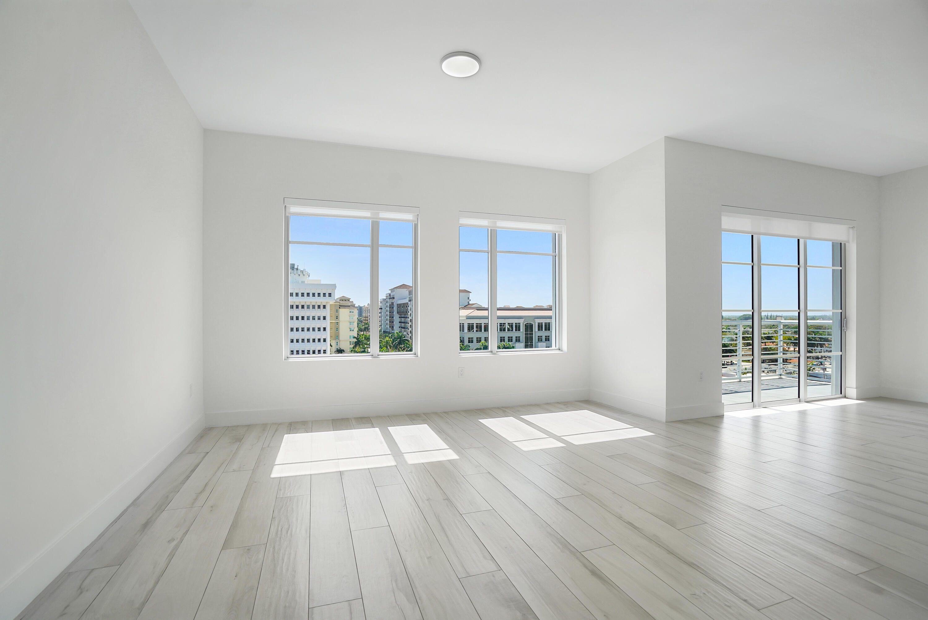 155 East Boca Raton Road, Unit 816 Boca Raton, FL 33432 - Photo 6 of 60 an empty room with wooden floor and windows