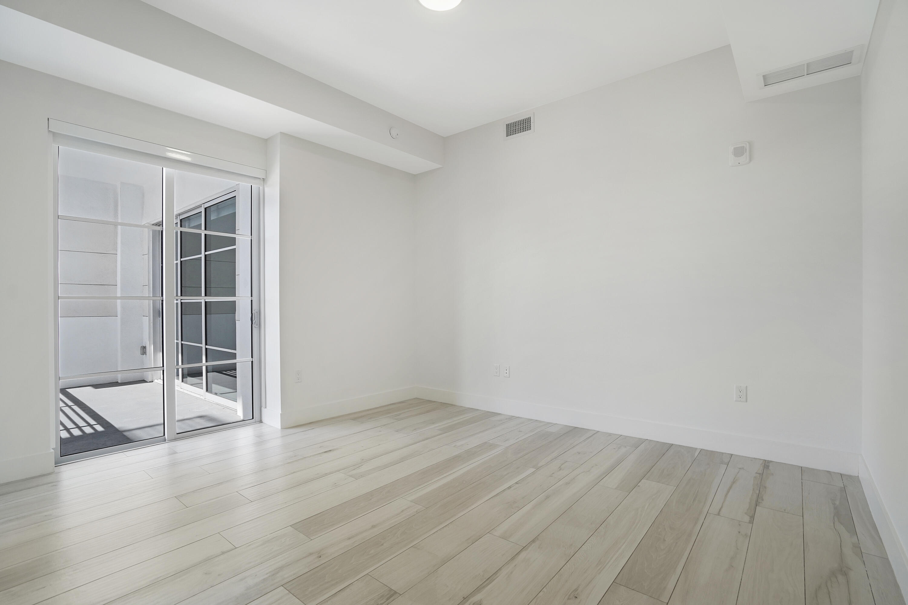 155 East Boca Raton Road, Unit 816 Boca Raton, FL 33432 - Photo 10 of 60 an empty room with wooden floor and windows
