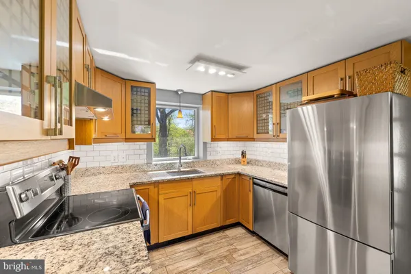 a kitchen with granite countertop stainless steel appliances a sink stove and refrigerator