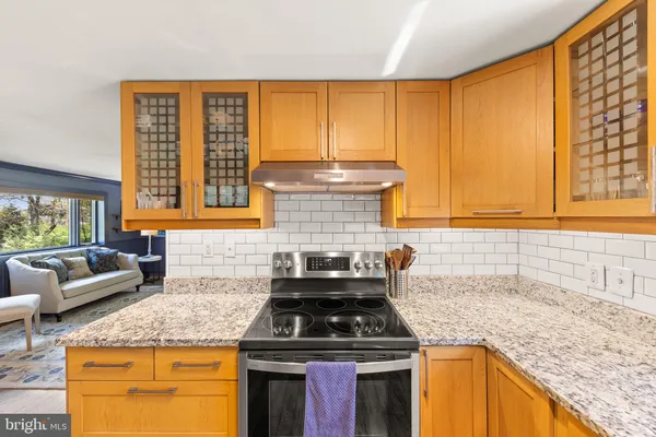 a kitchen with granite countertop wooden cabinets and a stove