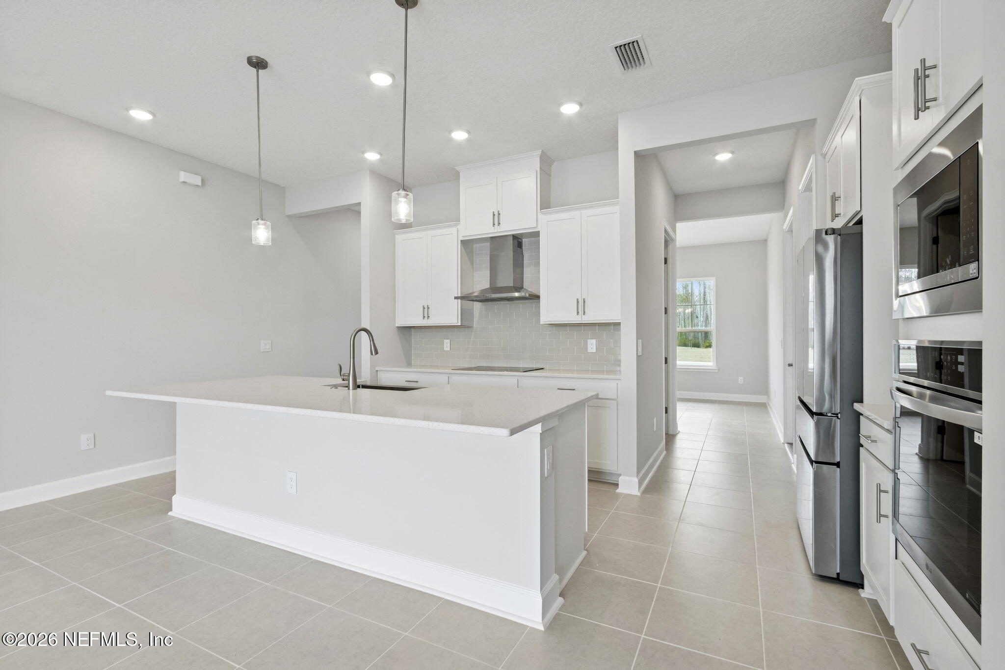 85321 Sandy Rdg Loop Yulee, FL 32097 - Photo 16 of 49 a large kitchen with stainless steel appliances kitchen island granite countertop a sink and a refrigerator