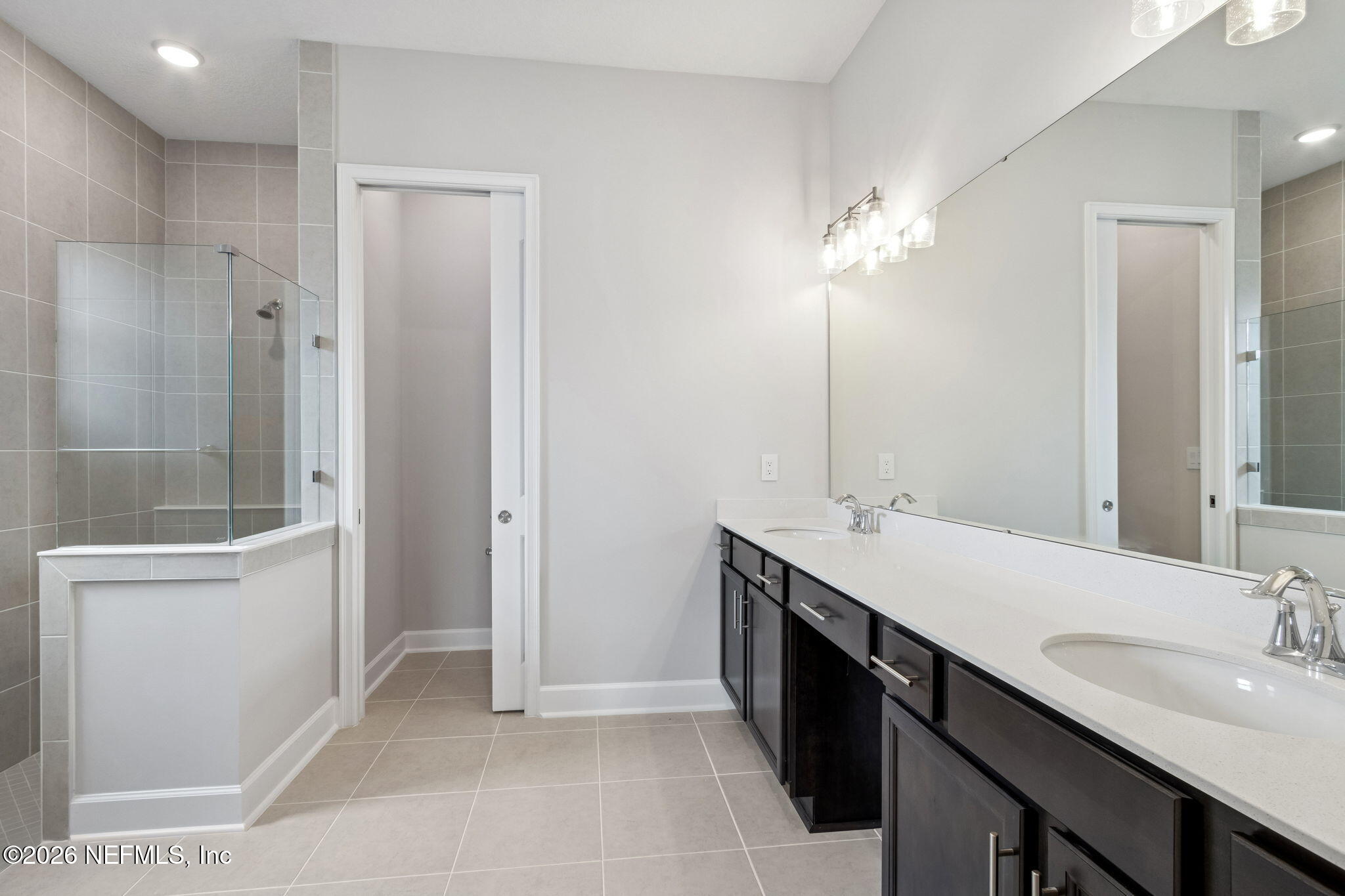 85321 Sandy Rdg Loop Yulee, FL 32097 - Photo 26 of 49 a bathroom with a double vanity sink a large mirror and a shower