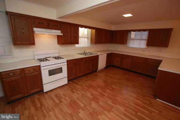 12414 Flack Street Silver Spring, MD 20906 - Photo 3 of 16 a kitchen with stainless steel appliances granite countertop a stove a sink and a microwave