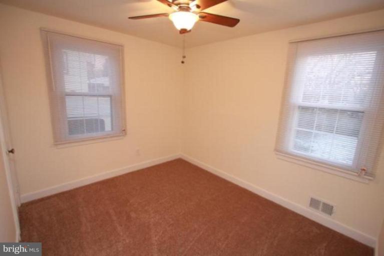 12414 Flack Street Silver Spring, MD 20906 - Photo 8 of 16 an empty room with a window and a fan