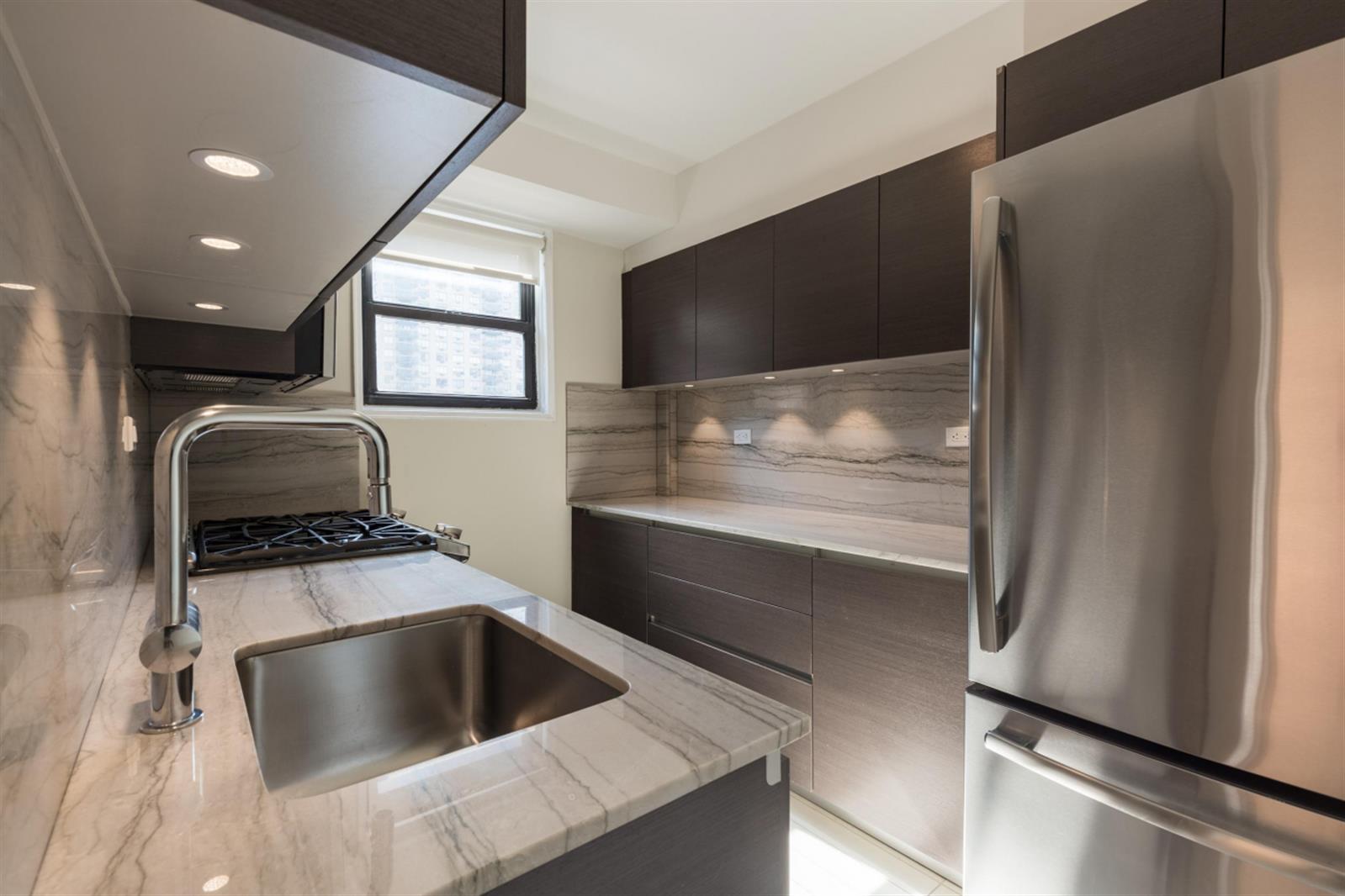 141 East 33rd Street, Unit 4B Manhattan, NY 10016 - Photo 5 of 9 a kitchen with a sink and a refrigerator
