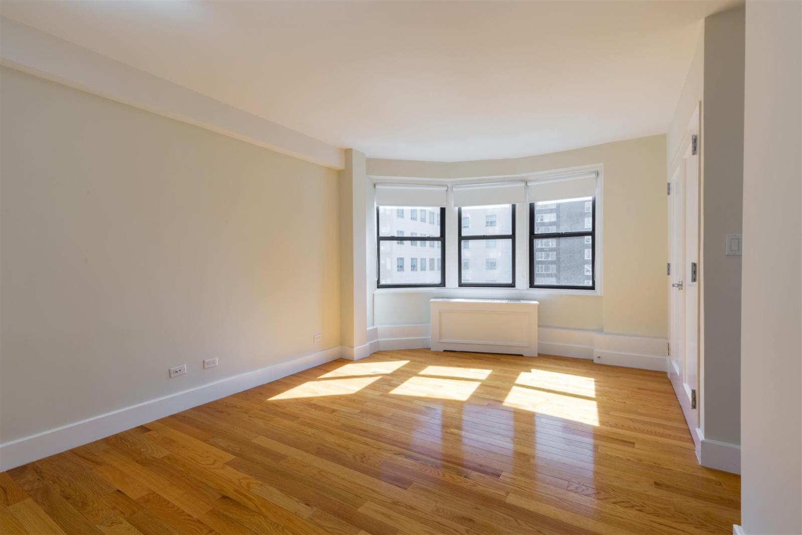 141 East 33rd Street, Unit 4B Manhattan, NY 10016 - Photo 6 of 9 wooden floor in an empty room with a window