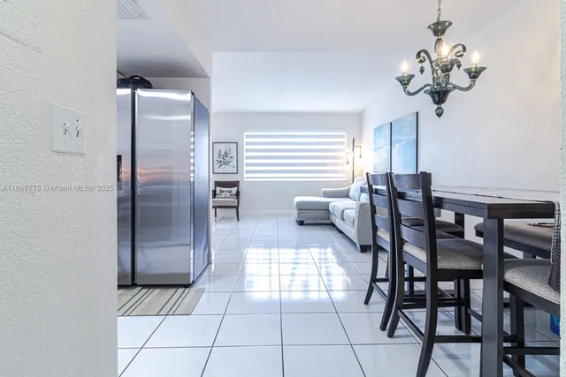 a kitchen with stainless steel appliances kitchen island granite countertop a table and chairs in it