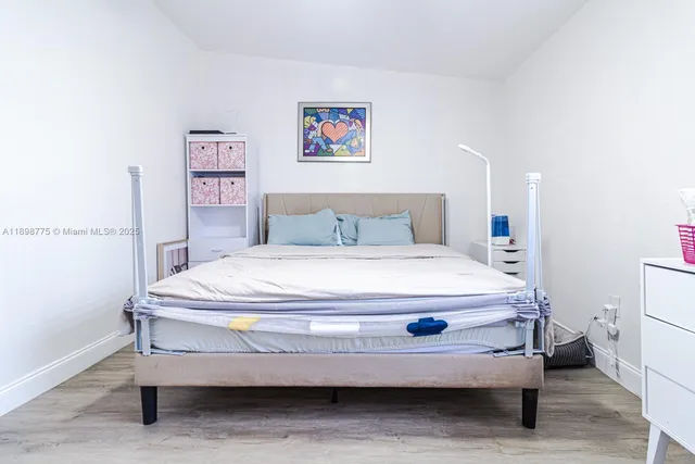 a bedroom with a bed and a wall painting