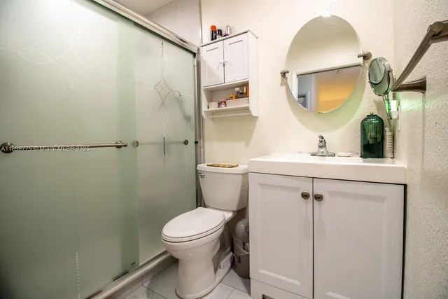 a bathroom with a toilet a sink and mirror