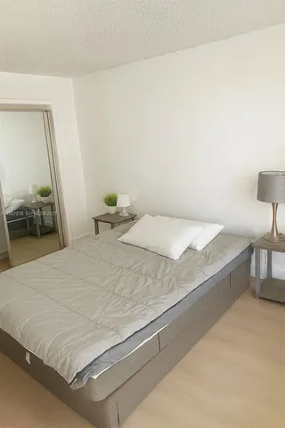 a bedroom with a bed and a lamp on table