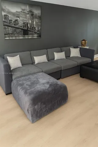 a living room with furniture and a view of kitchen