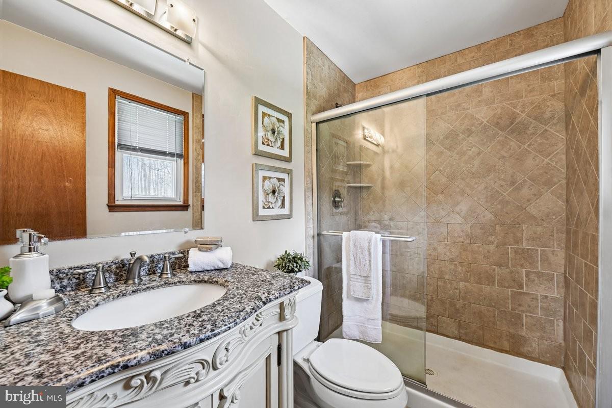 16601 Candy Hill Road Upper Marlboro, MD 20772 - Photo 16 of 55 a bathroom with a granite countertop sink toilet a mirror a vanity and shower