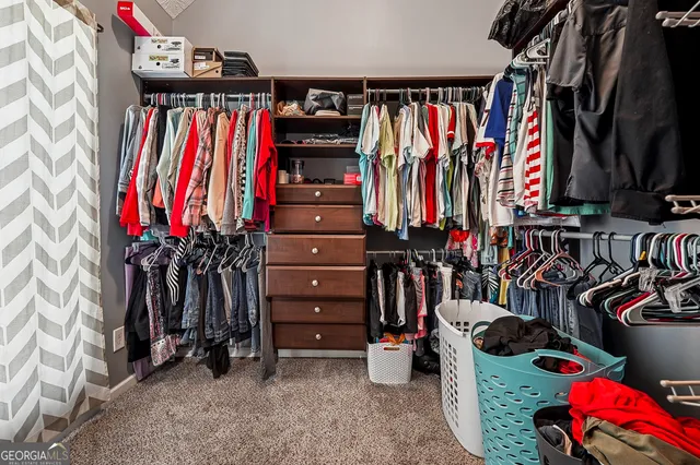 a view of walk in closet with clothes