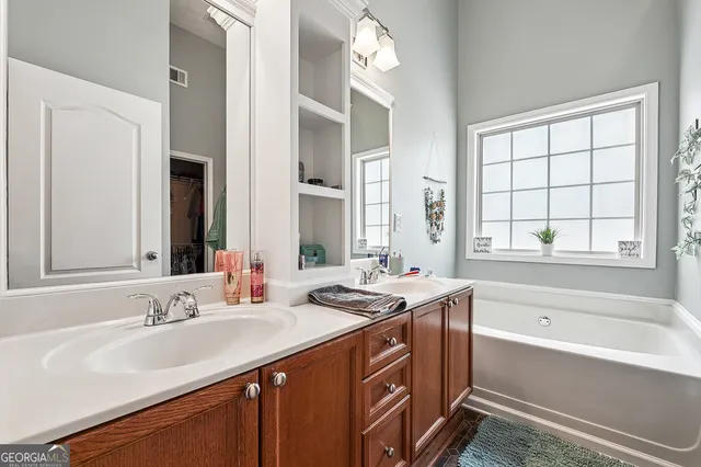 a bathroom with a granite countertop sink and a bathtub