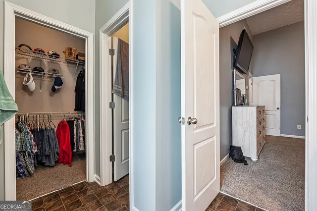 a view of walk in closet with clothes and shoes